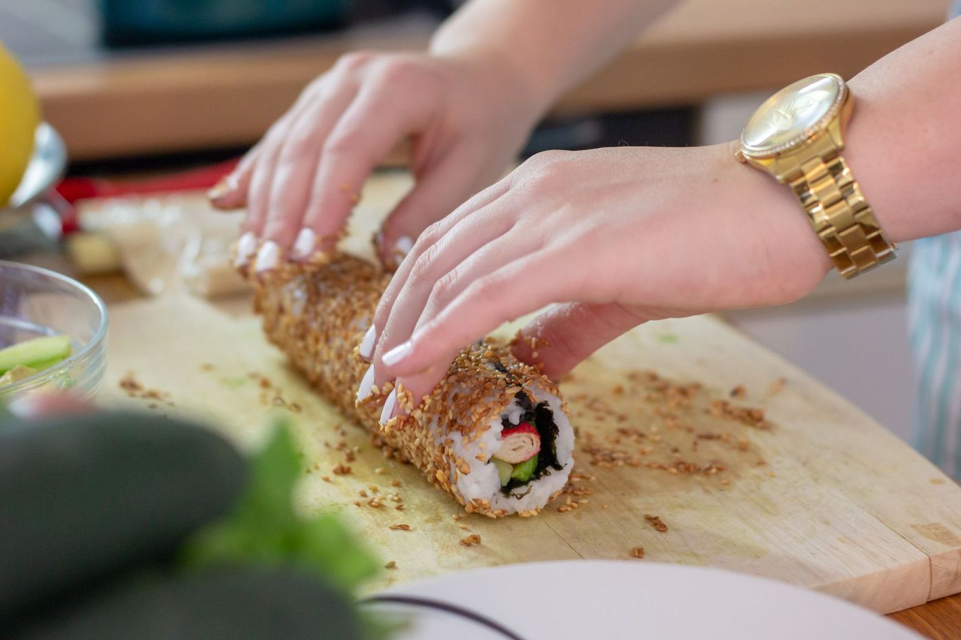 Hands rolling a sushi roll